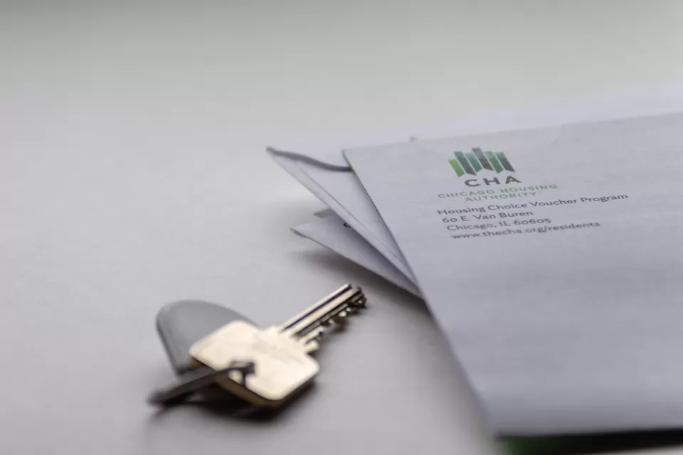 Close-up of house key on table and corner of envelope from Chicago Housing Authority